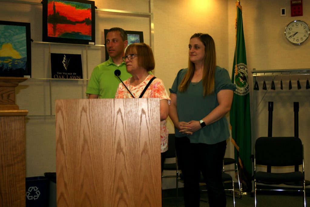 Patti Sullivan, the widow of Eugene "Skip" Sullivan, who was a teacher and coached varsity baseball and other sports at Oak Lawn Community High School, thanked the Oak Lawn Village Board Tuesday night for proclaiming Tuesday, May 17, as "Skip Sullivan Day" in the village. She was accompanied by her son, Mike Sullivan, and daughter, Dana Annel. (Photo by Joe Boyle)