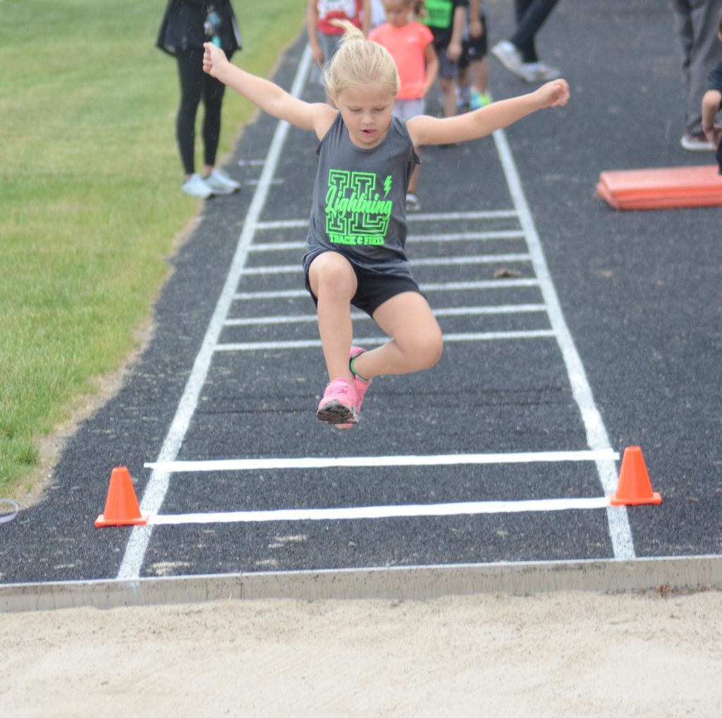 Harper Noren of the Illinois Lightning Track Club shows her form in the long jump on June 25 at Shepard. Photo by Jeff Vorva