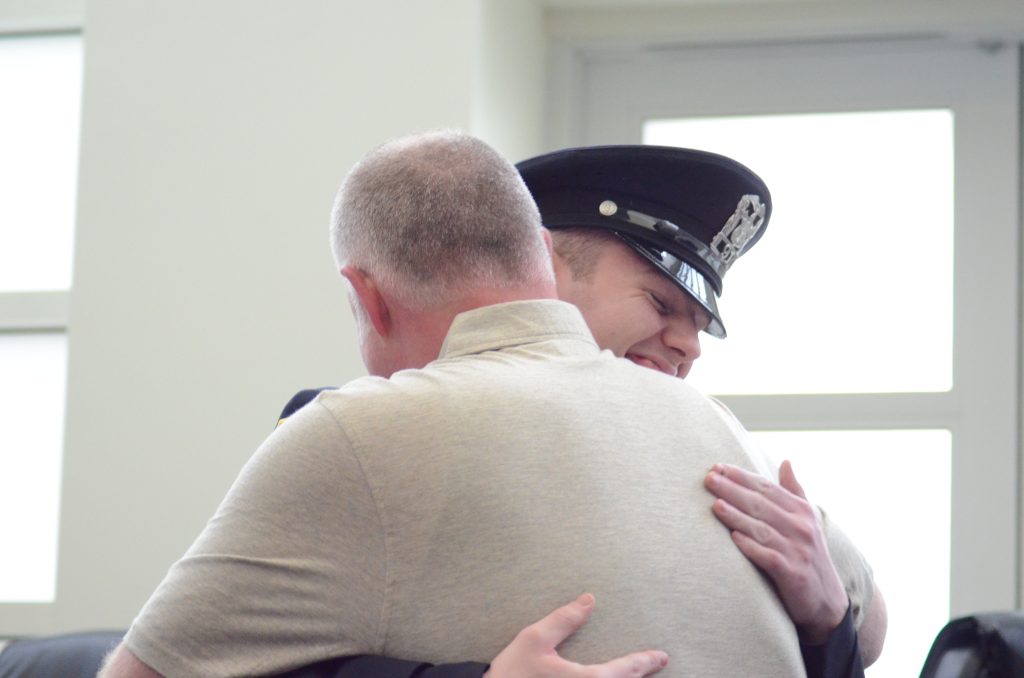 Orland Park police officer Ryan Kielar-McNamara receives a hug from his father, Kevin, Monday night during the quarterly awards ceremony. (Photo by Jeff Vorva)