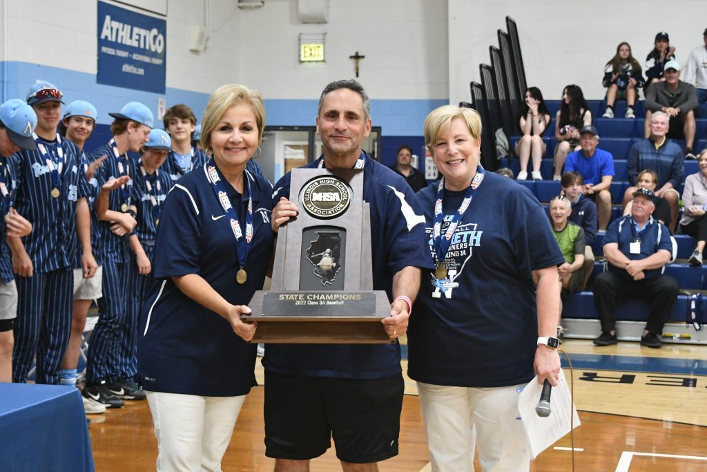 Coach Lee Milano presents Nazareth President Deborah Tracy and Principal Therese Hawkins with the 2022 State Championship trophy. (Supplied photo)