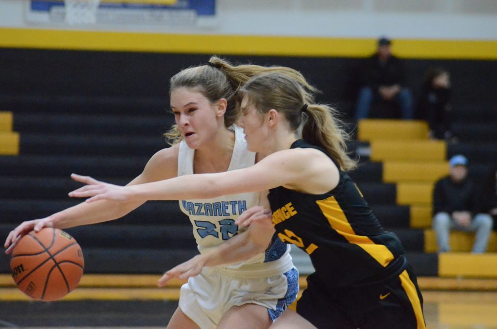 Nazareth's Gracie Carstensen, left, is guarded closely by St. Laurence freshman Sara Burzycki in Thursday's Class 3A regional final game in Burbank. Photo by Jeff Vorva
