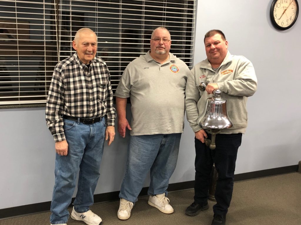 Forest View Fire Chief Mark Jones (right), holds a bell the department received back from Allen Kalas (left). Les Antos Jr.  donated a strainer back that was used years ago. (Photos by Carol McGowan) 