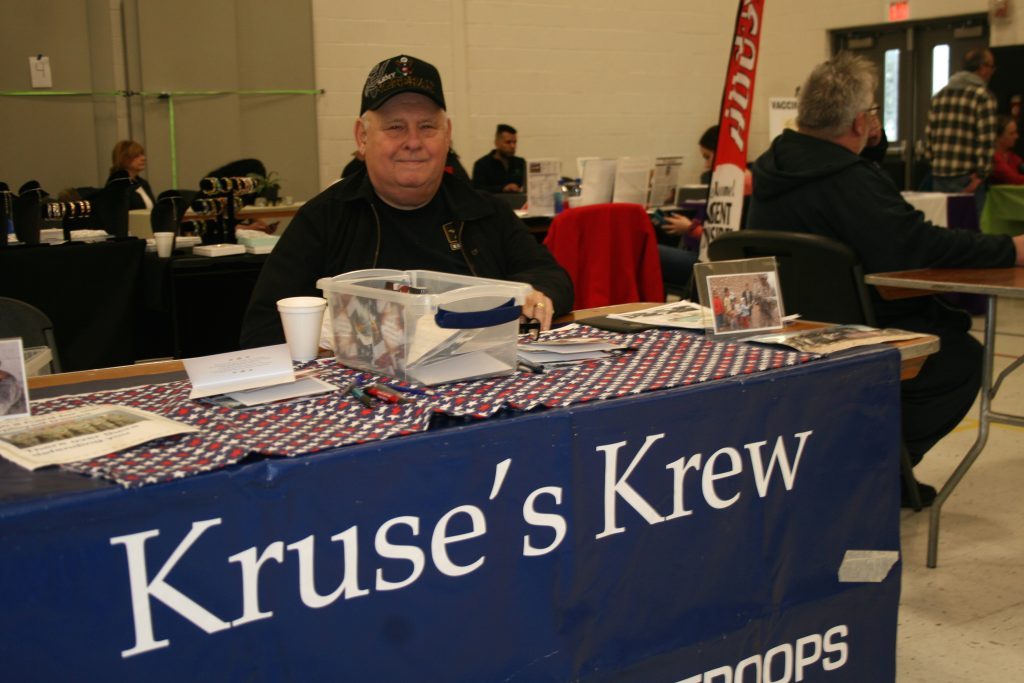 Jim Kruse, a Vietnam Army War veteran, talks to visitors and asking them to provide care packages for U.S. servicemen and women stationed overseas. He was at the Hills Chamber Business and Community Expo last Saturday at Conrady Junior High School in Hickory Hills. (Photos by Joe Boyle)