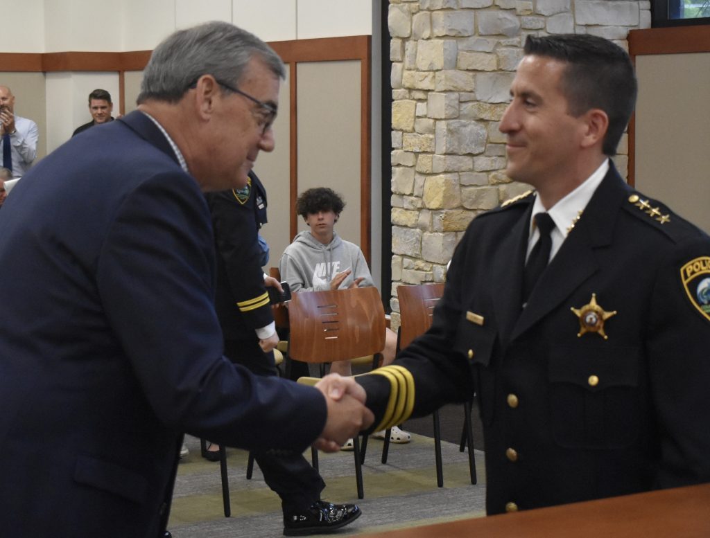Paul Klimek shakes hands with Countryside Mayor Sean McDermott after he was sworn in as police chief during the May 24 city council meeting. (Photo by Steve Metsch)