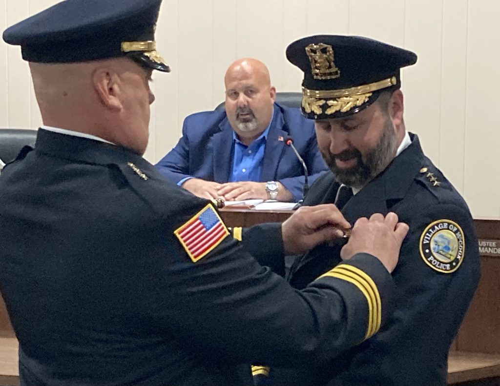 McCook Mayor Terrance Carr watches as outgoing Police Chief pins the star on the jacket of new chief Jeremy Carr, the mayor’s younger brother. (Photo by Steve Metsch)