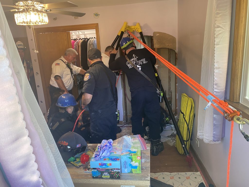 Orland firefighters get ready to pull a man out of a well in the basement of an Orland Park home. (Photos courtesy of Orland Fire Protection District)