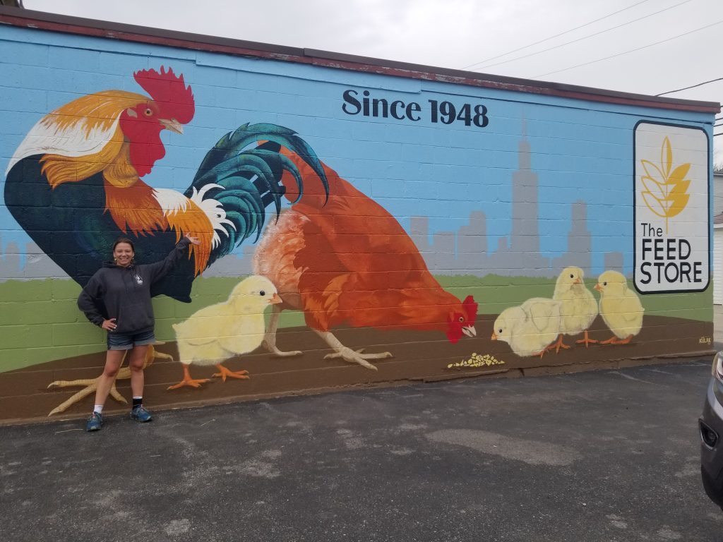 Brooke Bestwina, owner of The Feed Store in Summit, stands in front of a new mural to celebrate 75 years in business. (Photos by Carol McGowan)
