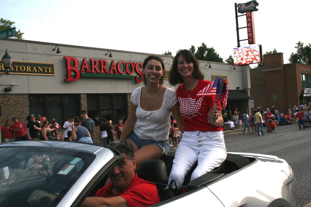 Mayor Kelly Burke holds some American flags and is accompanied by her daughter, Caroline, while her husband, Terry, drives during the Evergreen Park Independence Day Parade June 30 near 95th and Lawndale. (Photos by Joe Boyle)