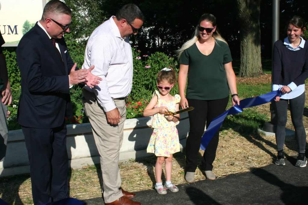 A ribbon-cutting ceremony took place Monday night to unveil the upgraded Lewandowski Park in Oak Lawn. Isabel White, 5, was chosen to cut the ribbon as (from left) Dan Johnson, president of the Oak Lawn Park District Board of Commissioners, and Tom Hartwig, executive director of the Oak Lawn Park District, look on. (Photos by Joe Boyle)