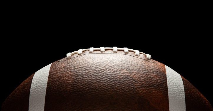 American football ball on dark background.