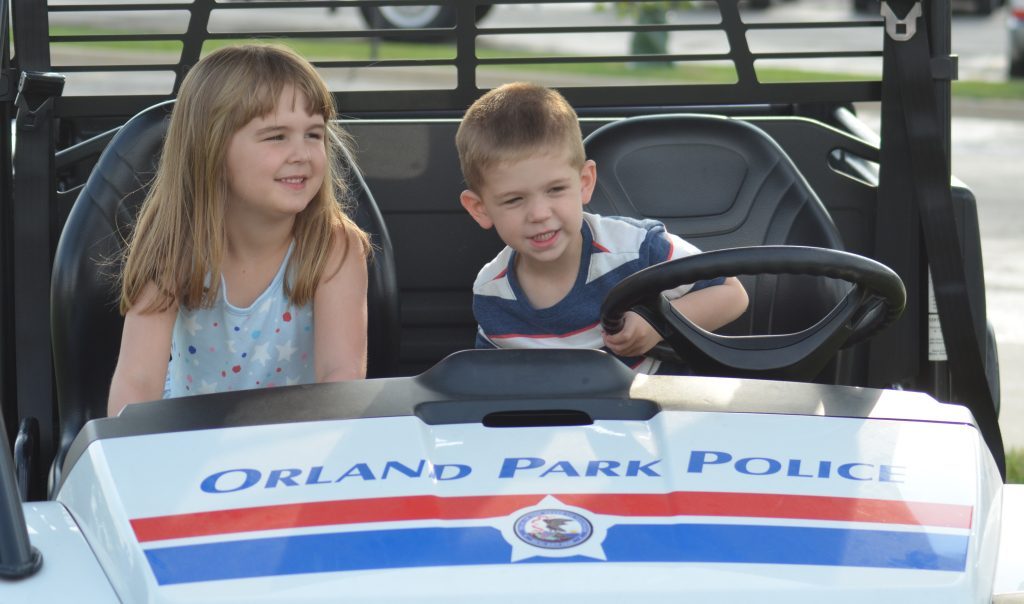 Claire and Tony Caturano, of New Lenox, play in an Orland Park police vehicle during the Aug. 1 Night Out event on the Village Green. (Photos by Jeff Vorva)
