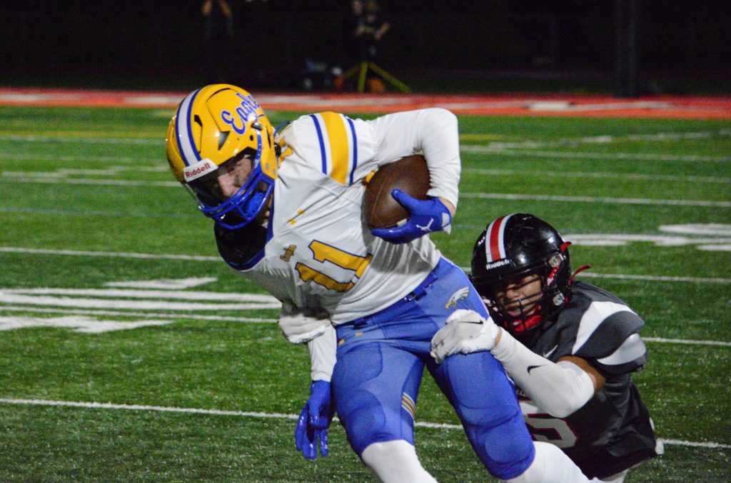 Sandburg wide receiver Charlie Snorek tries to slip the grasp of Lincoln-Way Central defender during the Knights’ 20-14 win on Sept. 22. Photo by Jason Maholy