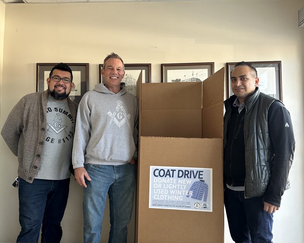 Manuel Jurado (from left), Worshipful Master Lodge 1133,  Lenny Svoboda, Past Master Lodge 1133, and Summit Mayor Sergio Rodriguez show off one of the coat collection boxes. (Supplied photo)
