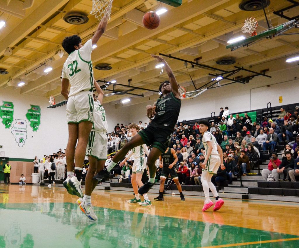 Oak Lawn forward Henry Martinez (32) goes up to block a shot by Evergreen Park guard Keshaun Crawl-Vava during the Spartans’ 68-66 victory on Dec. 8. Photo by Xavier Sanchez