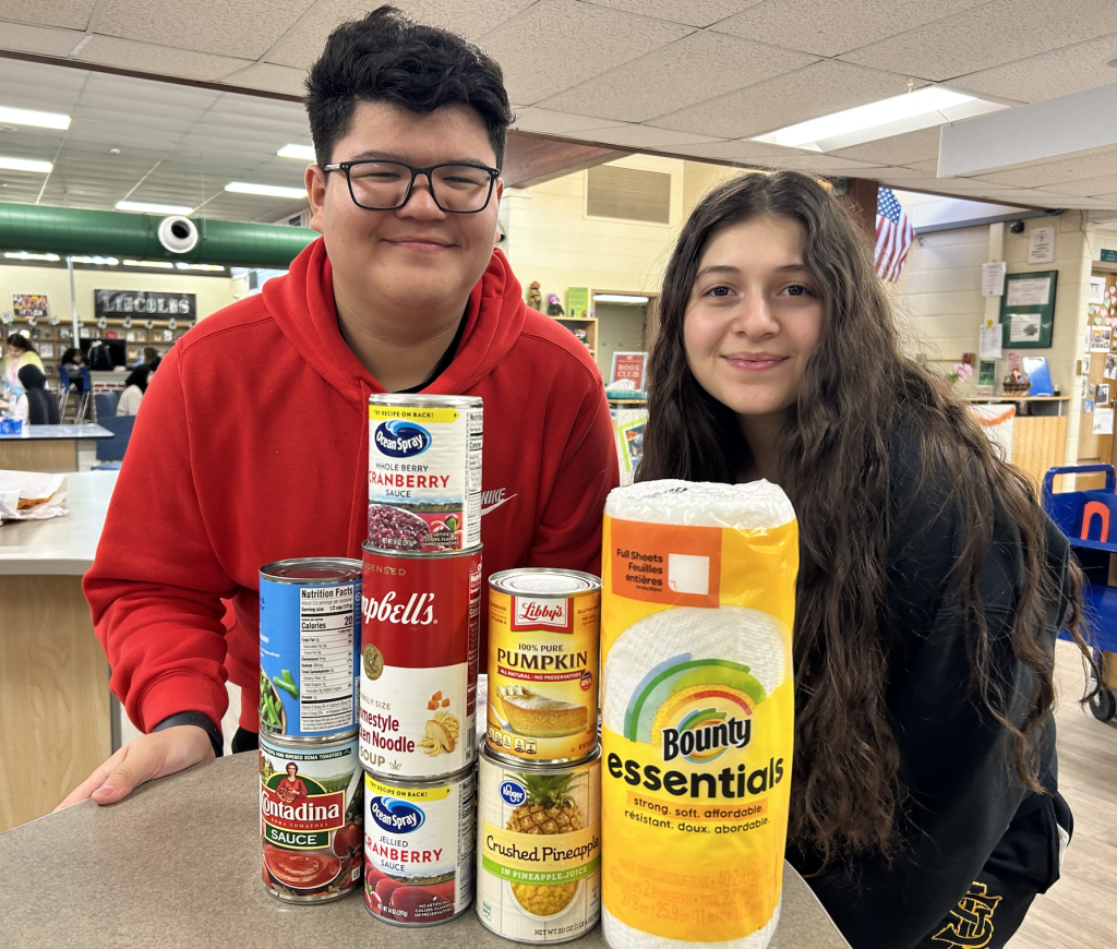 Oak Lawn Community High School students, Aiden Alarcon, 15, of Hometown and Sarah Abdallah, 14, of Oak Lawn, donating food to the high school's Student Council Food Drive. (Supplied photo)