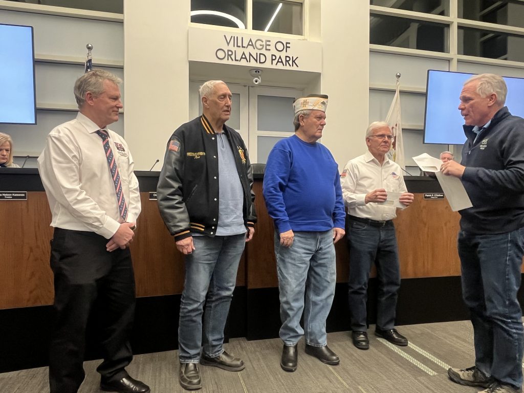 Orland Park Mayor Keith Pekau (right) gives out checks to local veterans' groups at the January 15 village board meeting. (Photo by Jeff Vorva)
