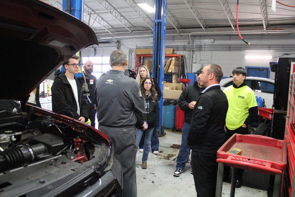 Christopher May, a trainer with the General Motors Automotive Service Education Program at Triton College, talks about career paths with teachers Matt Krogh (left) and Keith Luszcak and their students from Shepard and Richards high schools. (Supplied photos)