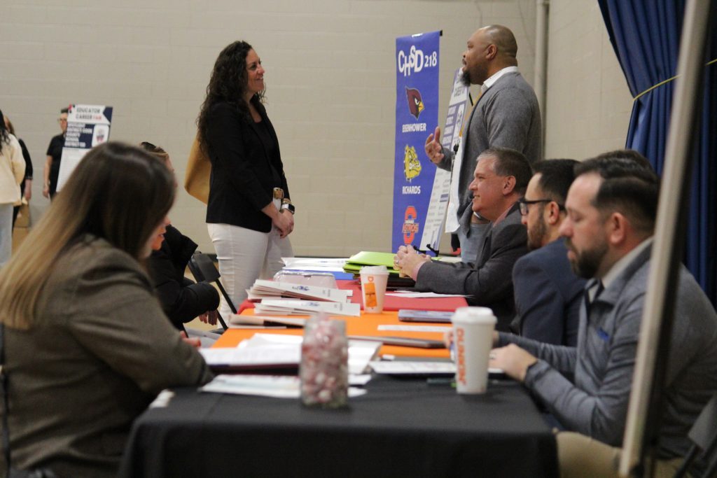 As Curriculum Director for English Ronell Whitaker (standing) talks with a candidate, his colleagues conduct interviews at the SD218 Educator Career Fair on February 24. (Supplied photos)