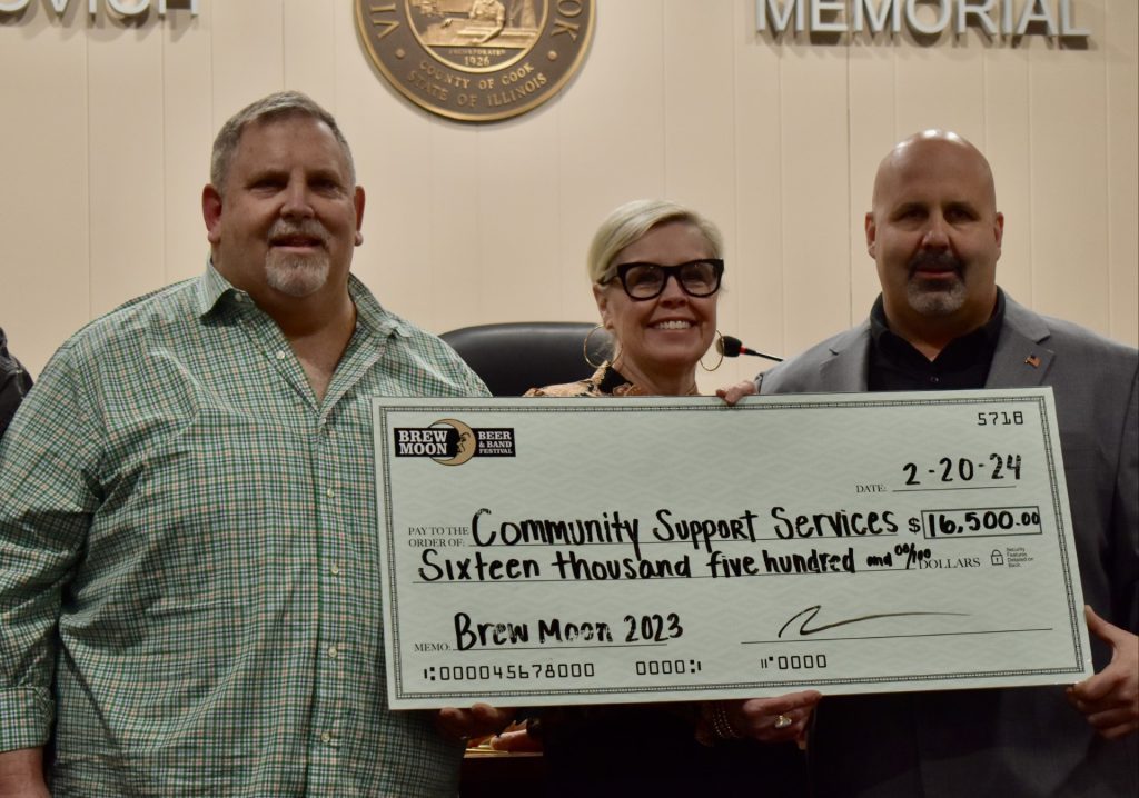 Steve Palmer, chairman of the Brew Moon Festival; Susanna Decker of Community Support Services; and McCook Mayor Terrance Carr pose with the oversized check donated from the festival. (Photos by Steve Metsch) 