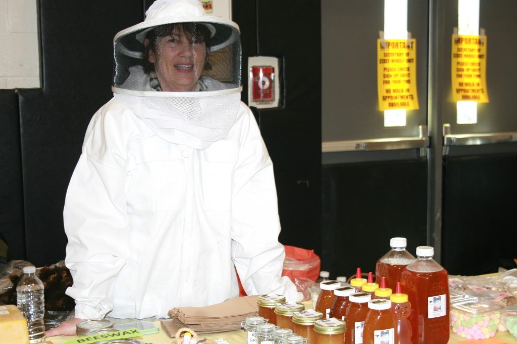 Sheri Cannataro, of Cannataro Farms, demonstrates the gear she wears to extract honey from a bee hive for visitors who stopped by to see her products at the Hills Chamber of Commerce Business and Community Expo Saturday at Conrady Junior High School in Hickory Hills. (Photos by Joe Boyle)