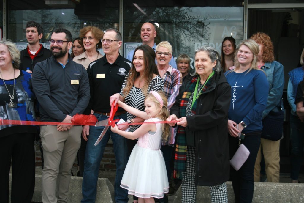 Melissa Kowalski, owner of Flair With Hair Salon in Chicago Ridge, prepares to cut the ribbon to mark the first anniversary of the business on April 18 with the assistance of her daughter, Anastasia, 5. (Photos by Joe Boyle)