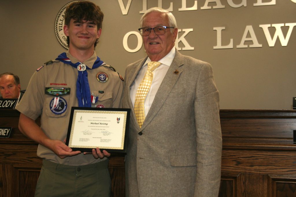 Mayor Terry Vorderer presents a plaque to Michael Reising for earning Eagle Scout recognition. The award was presented during the Oak Lawn Village Board meeting June 11 night. (Photo by Joe Boyle)